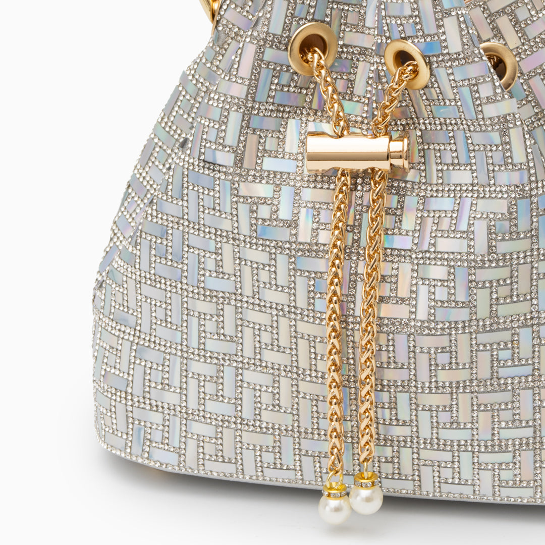 A stylish evening handbag featuring a mosaic design, metallic frame, and pearl accents close up of the side of the bag