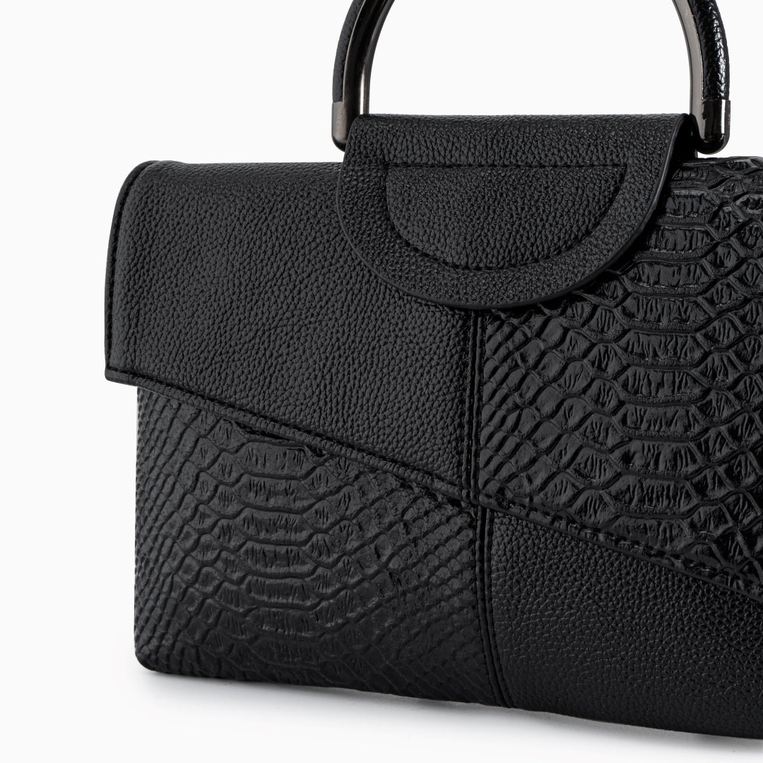 Elegant black shoulder bag made of genuine leather, semi close-up with white background.