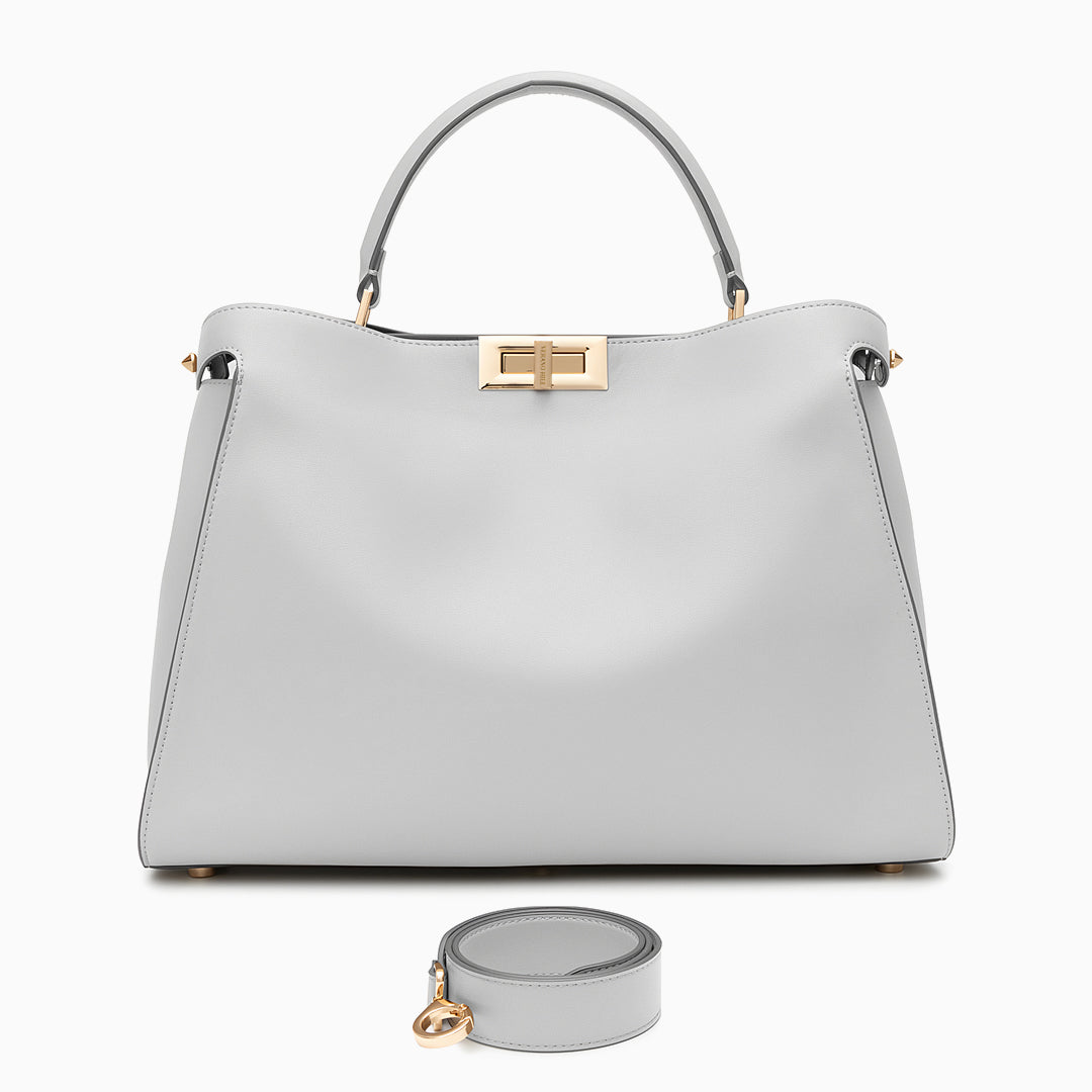 Light gray handbag with gold accents on a white background