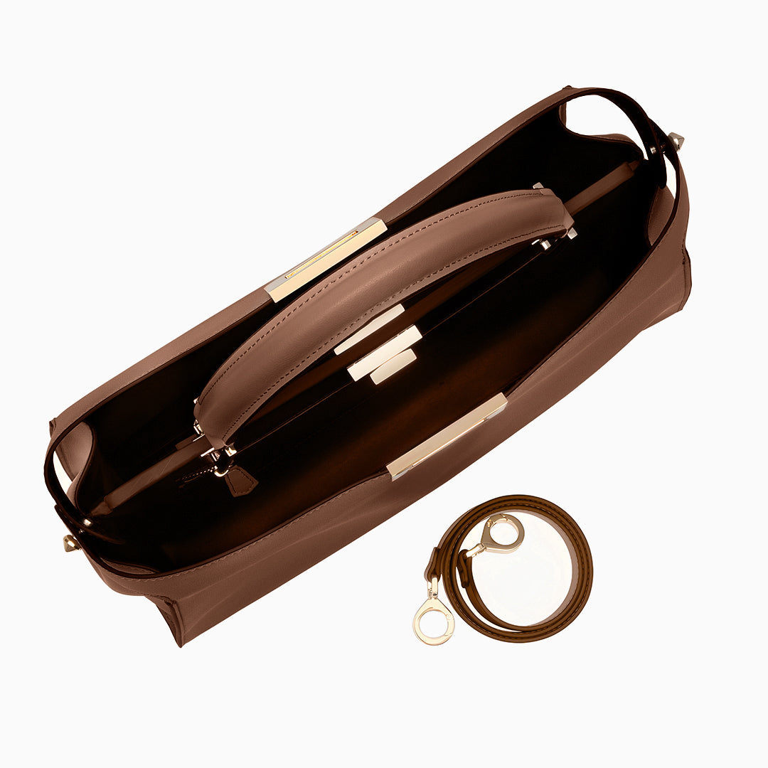 Brown leather handbag with a detachable strap on a white background