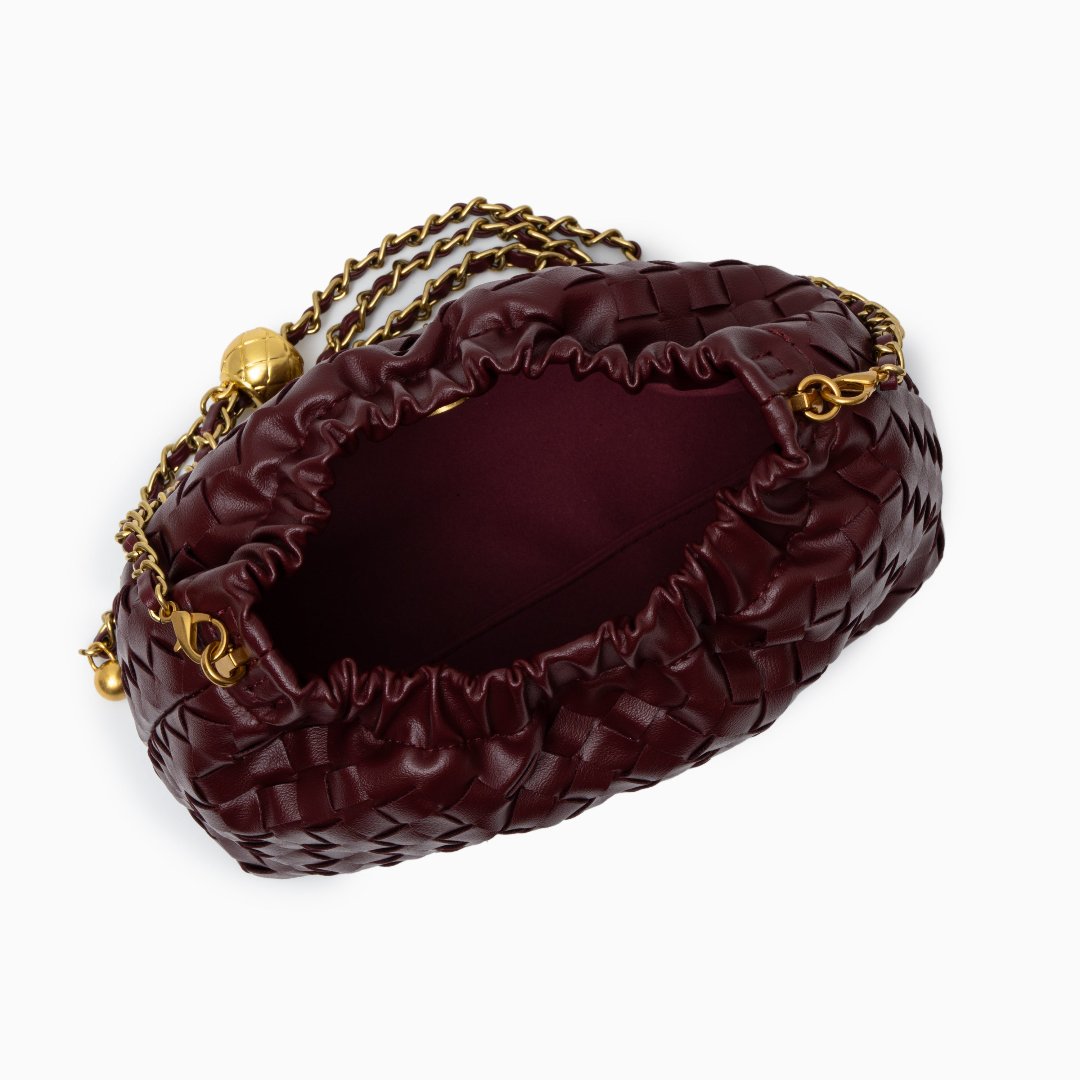 Maroon handbag with gold chain strap on a white background