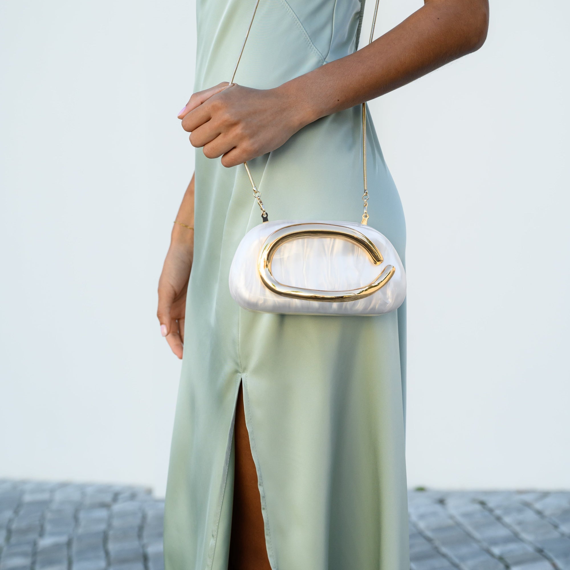 Sculptural gold clutch bag with a pearlescent acrylic finish, designed for elegant evening wear. 5