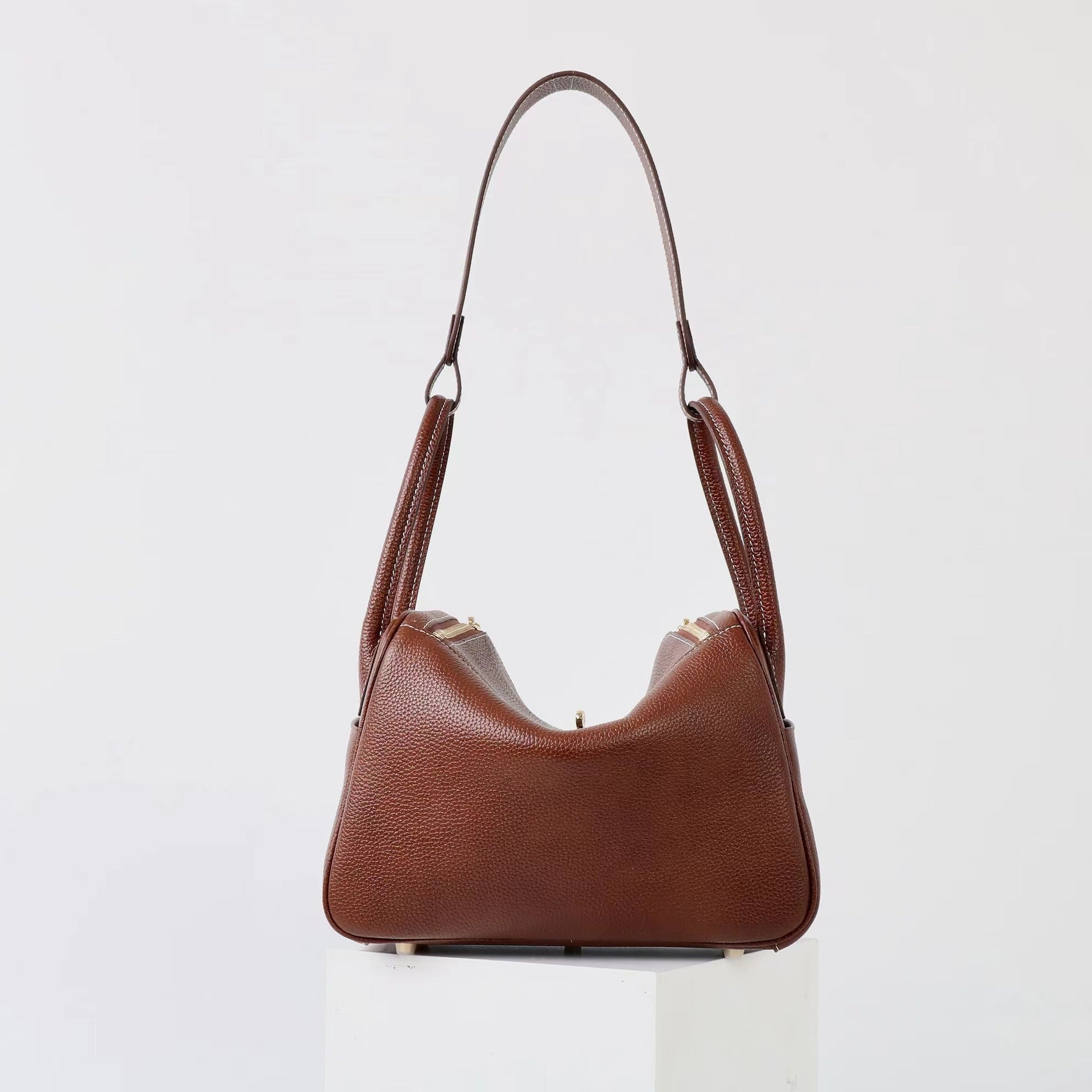 Black genuine leather mini shoulder bag with a curved flap design. 5