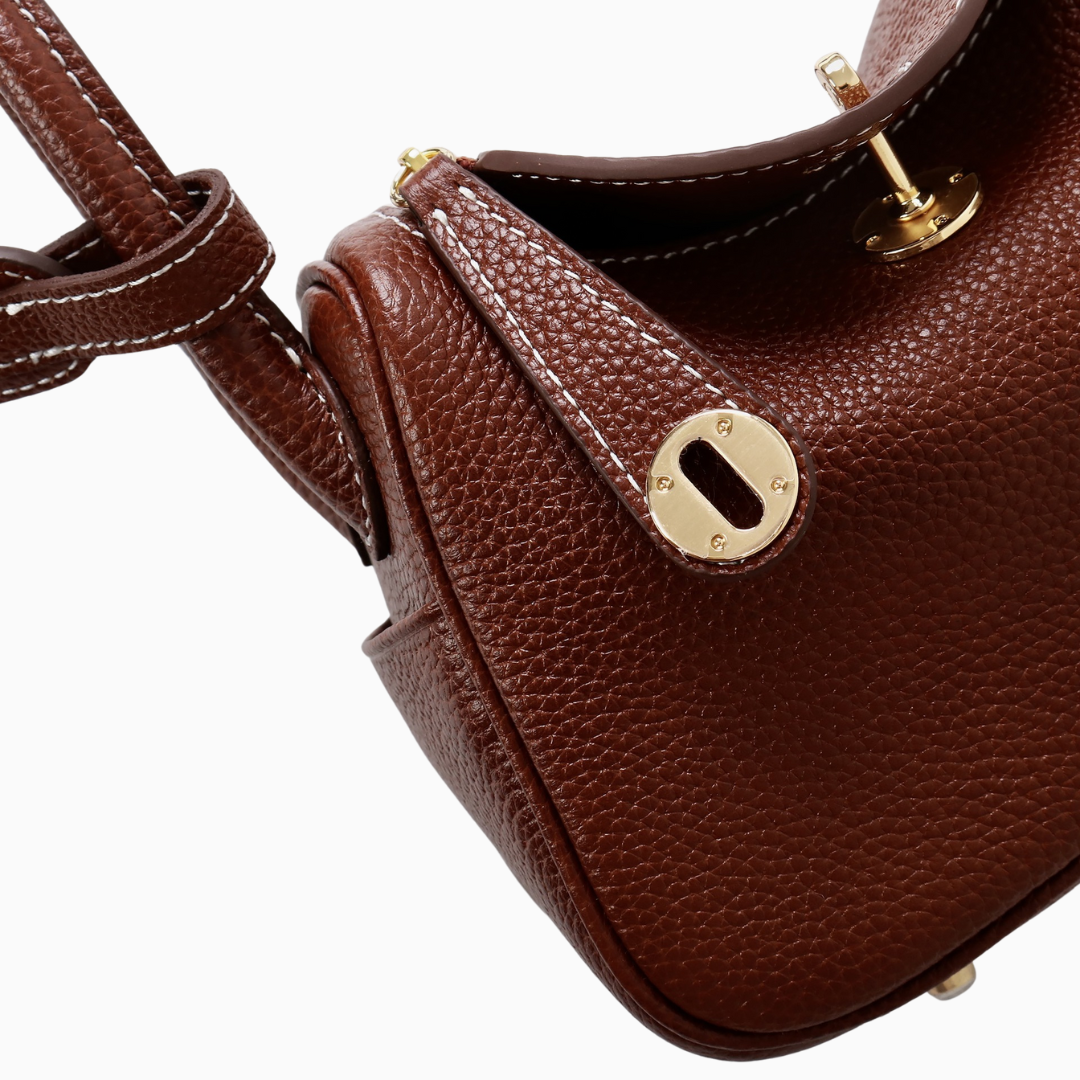 A black mini shoulder bag made of genuine leather featuring a curved flap design. 7