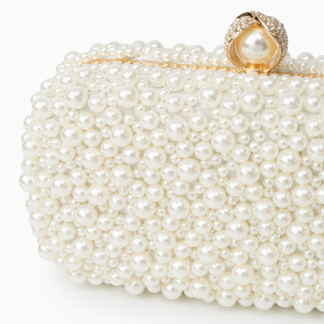 Pearl clutch bag with a decorative clasp on a white background