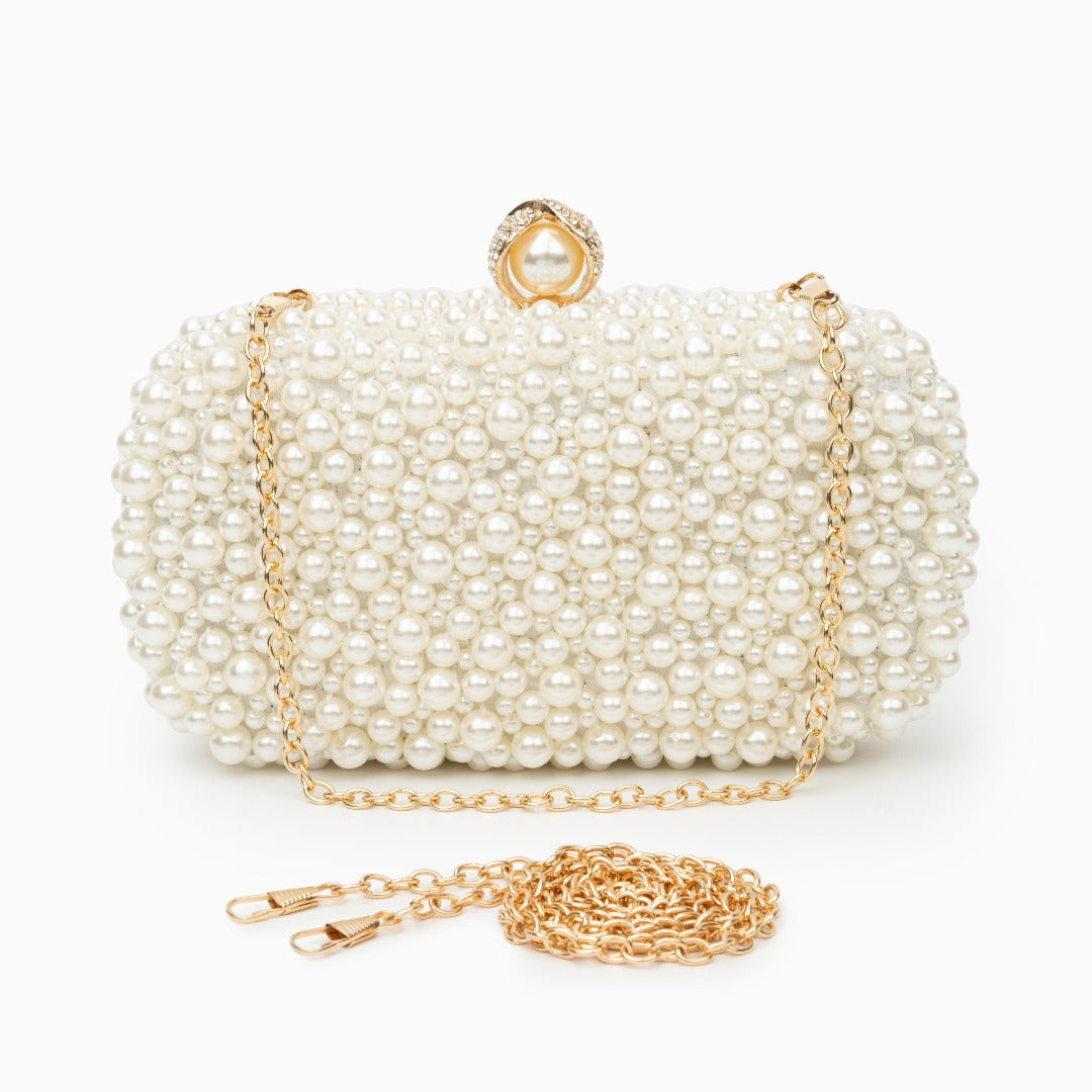 Pearl-handled clutch bag with gold chain on a white background