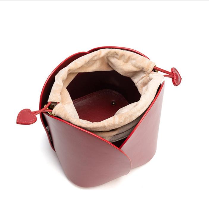 Burgundy bucket handbag with a heart-shaped closure. 4