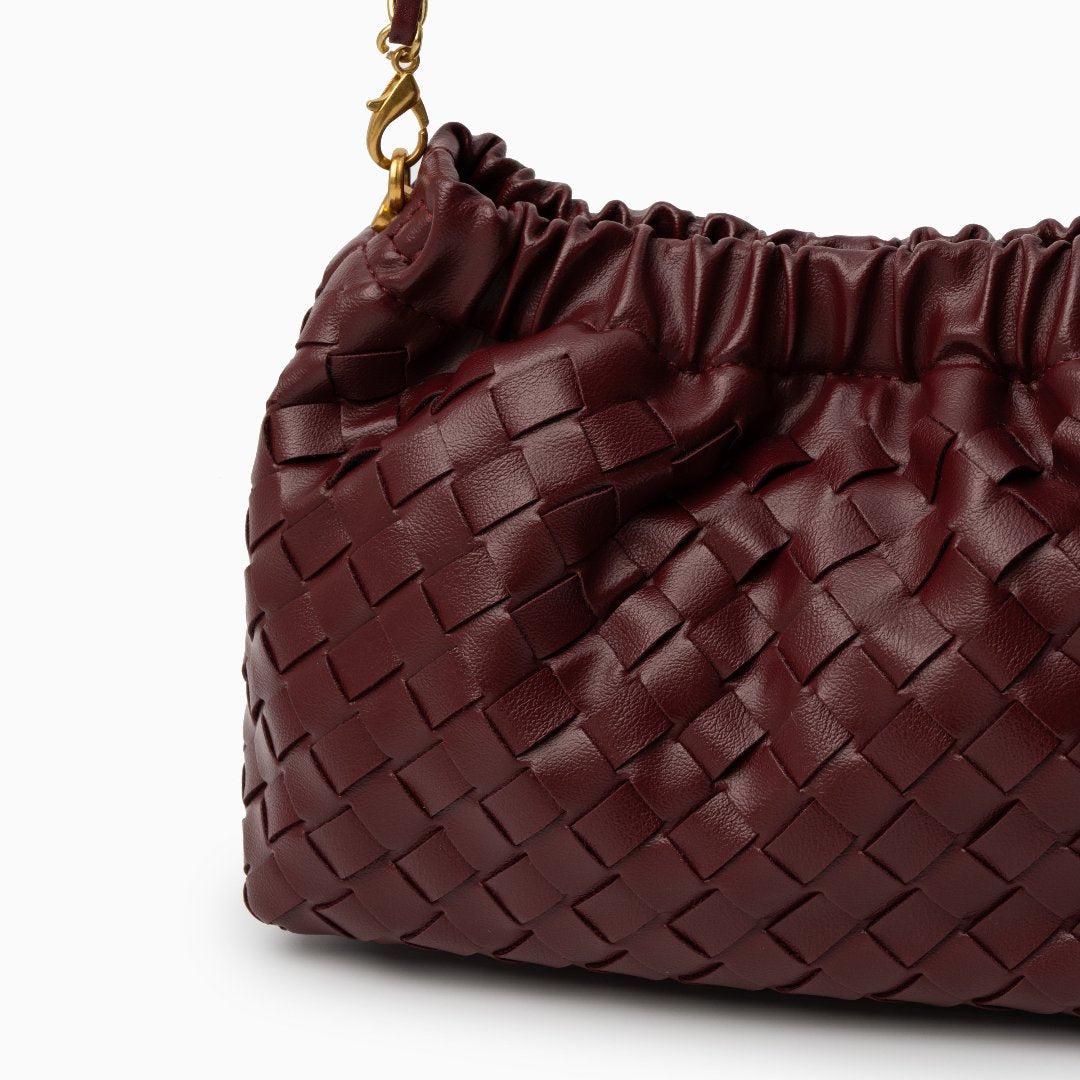 Chic black shoulder bag with a woven texture and gold braided strap. 2