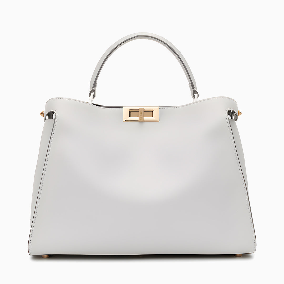White handbag with gold accents on a white background