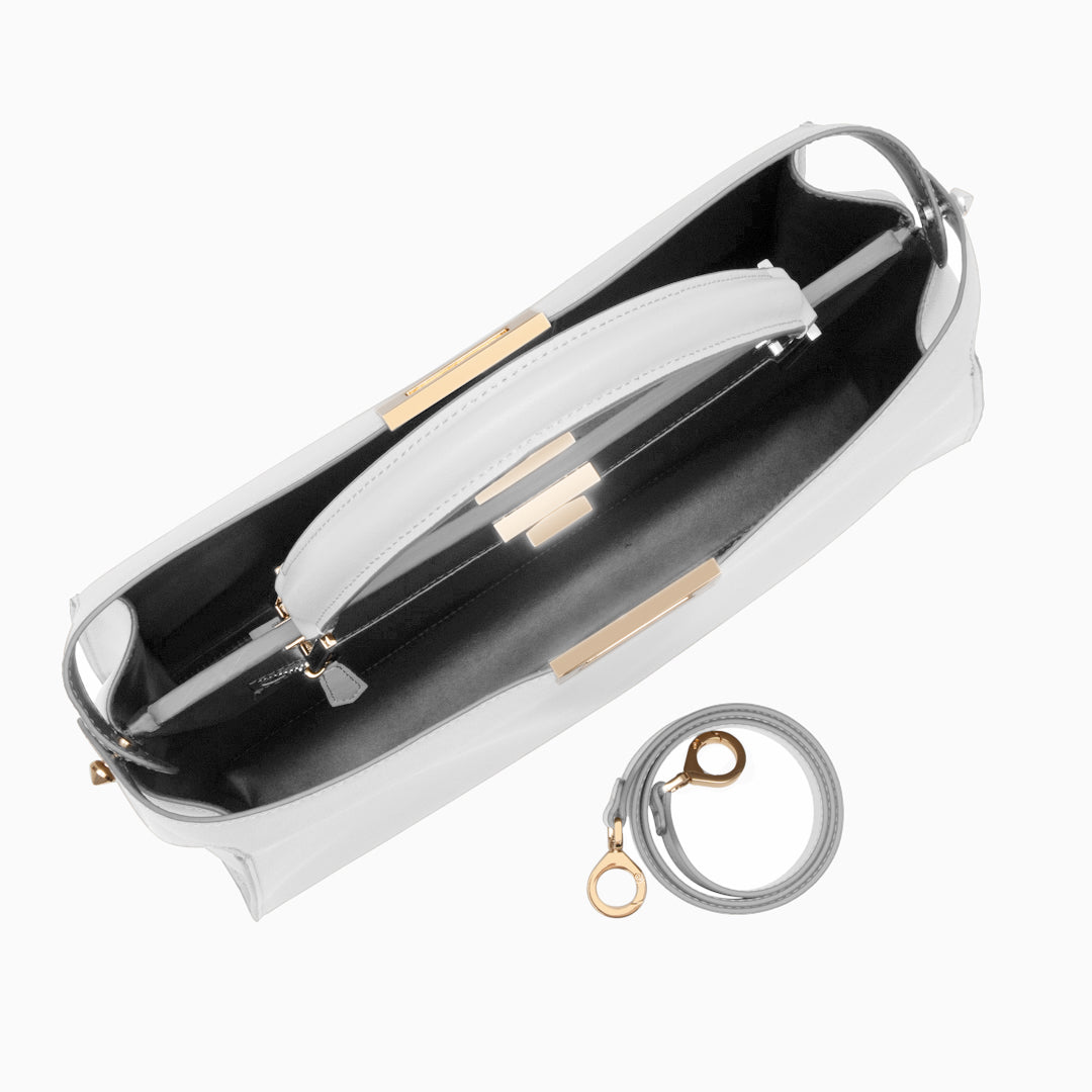 White handbag with gold accents on a white background