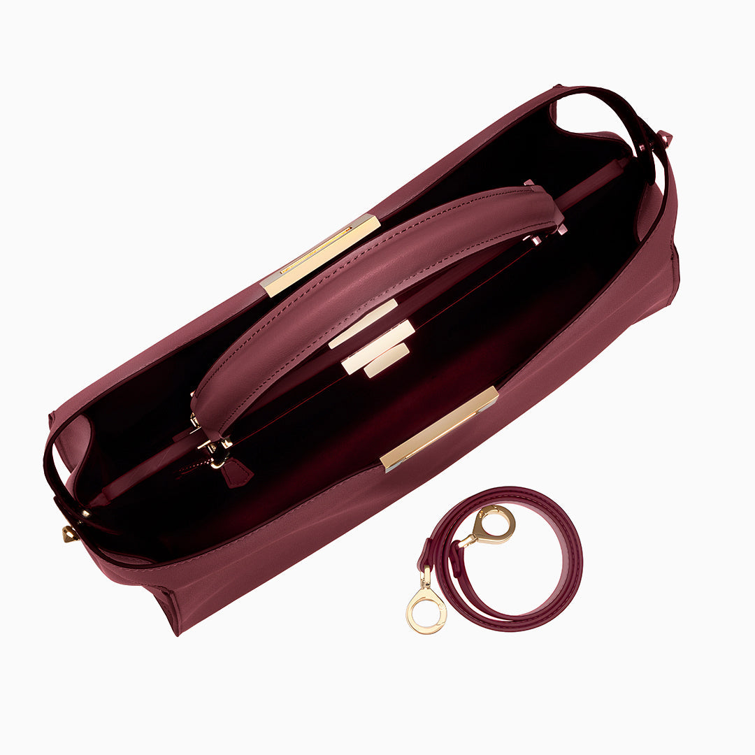 Top view of maroon handbag with gold accents on a white background