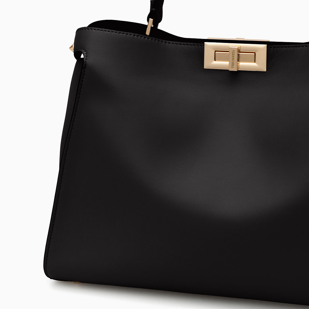 Black handbag with a gold clasp on a white background