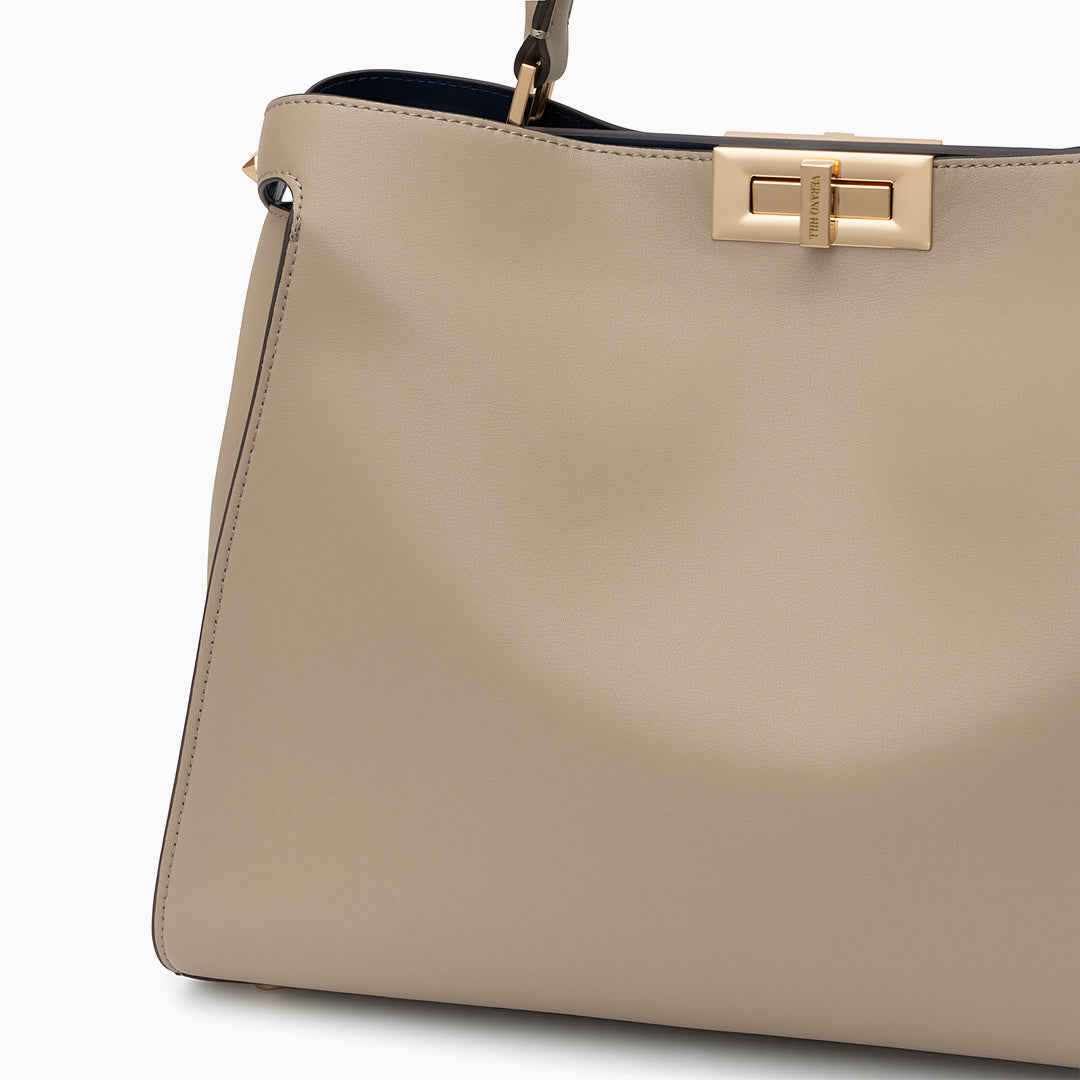 Beige handbag with a gold clasp on a white background