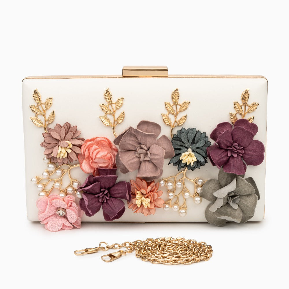 Clutch bag with floral decorations and a gold chain on a white background