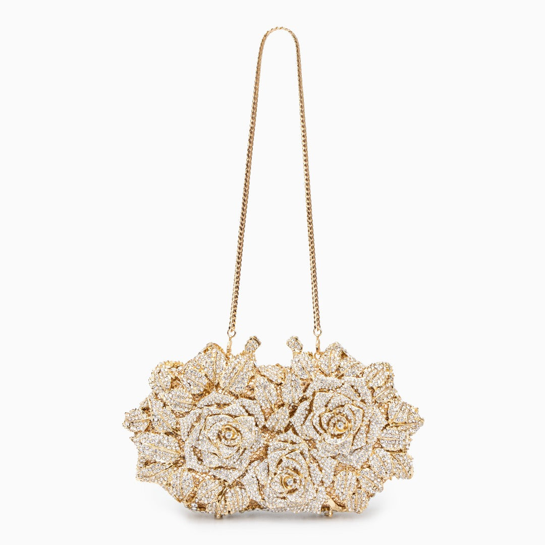 A gold clutch bag made of vegan leather, adorned with sparkling rhinestone accents. 