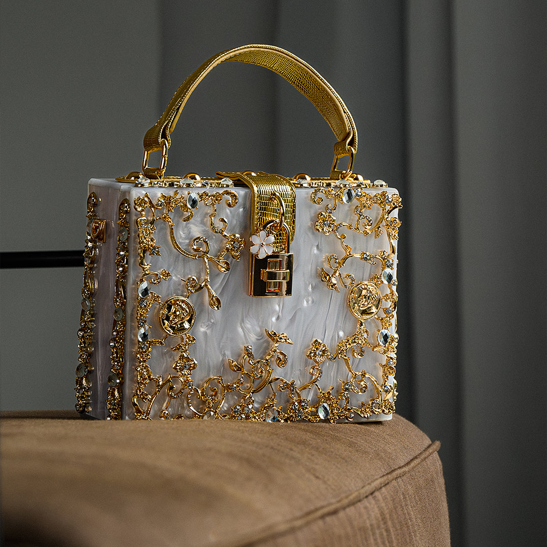 Decorative handbag with gold embellishments on a dark background