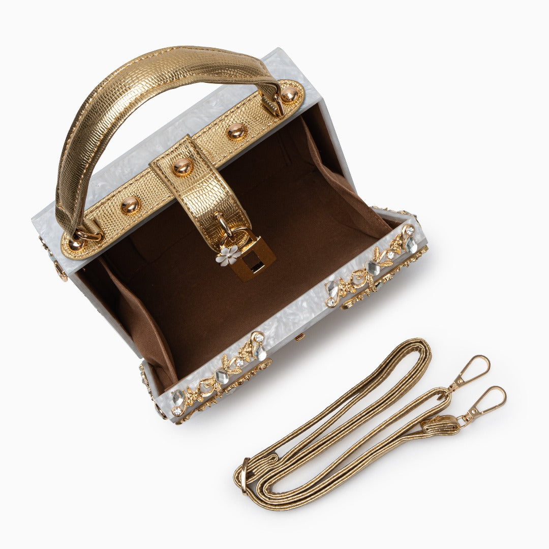 Gold handbag with decorative elements on a white background