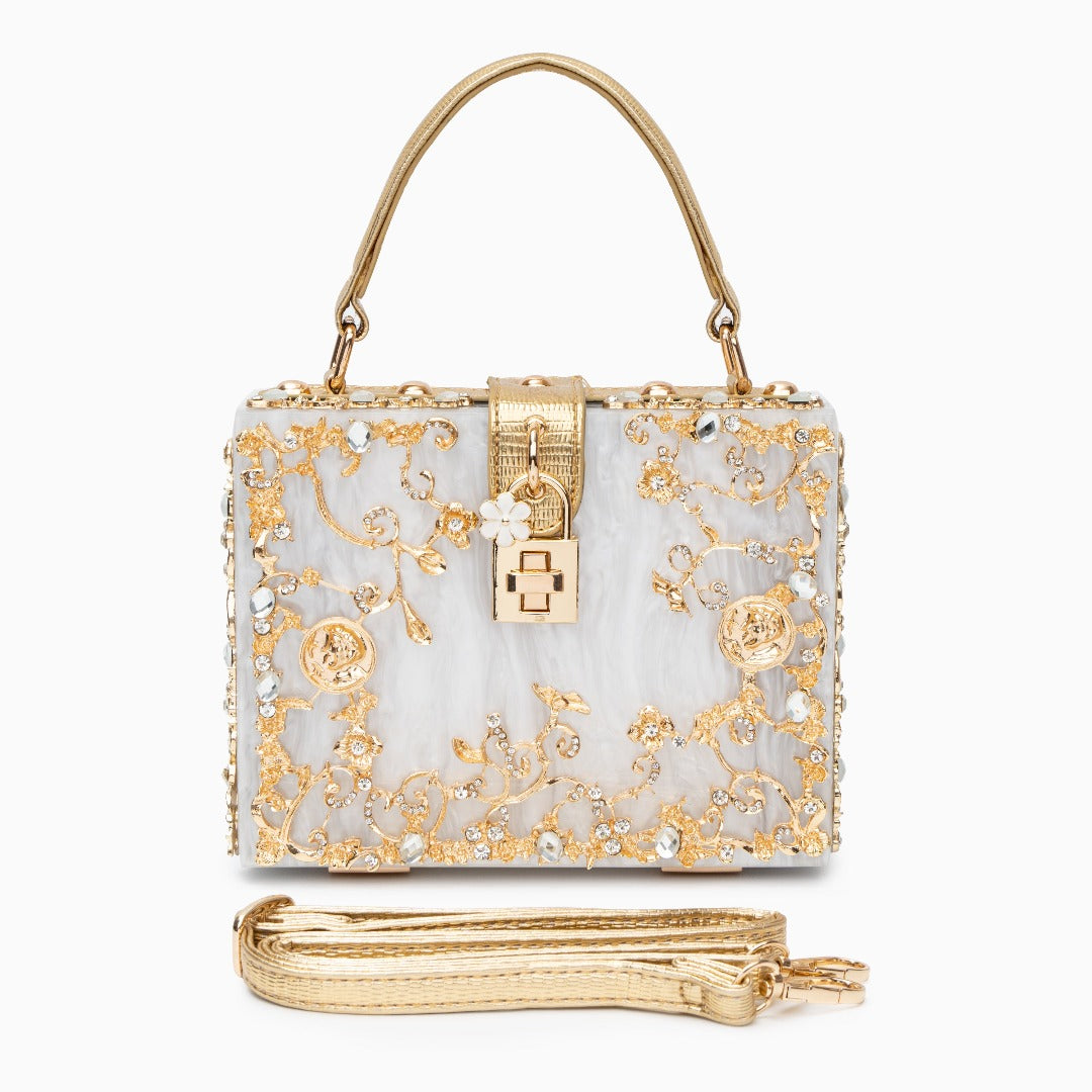 Decorative handbag with gold floral patterns on a white background