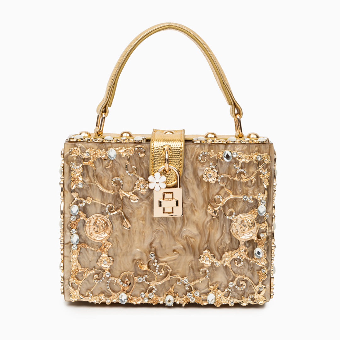 Gold handbag with intricate designs and embellishments on a white background