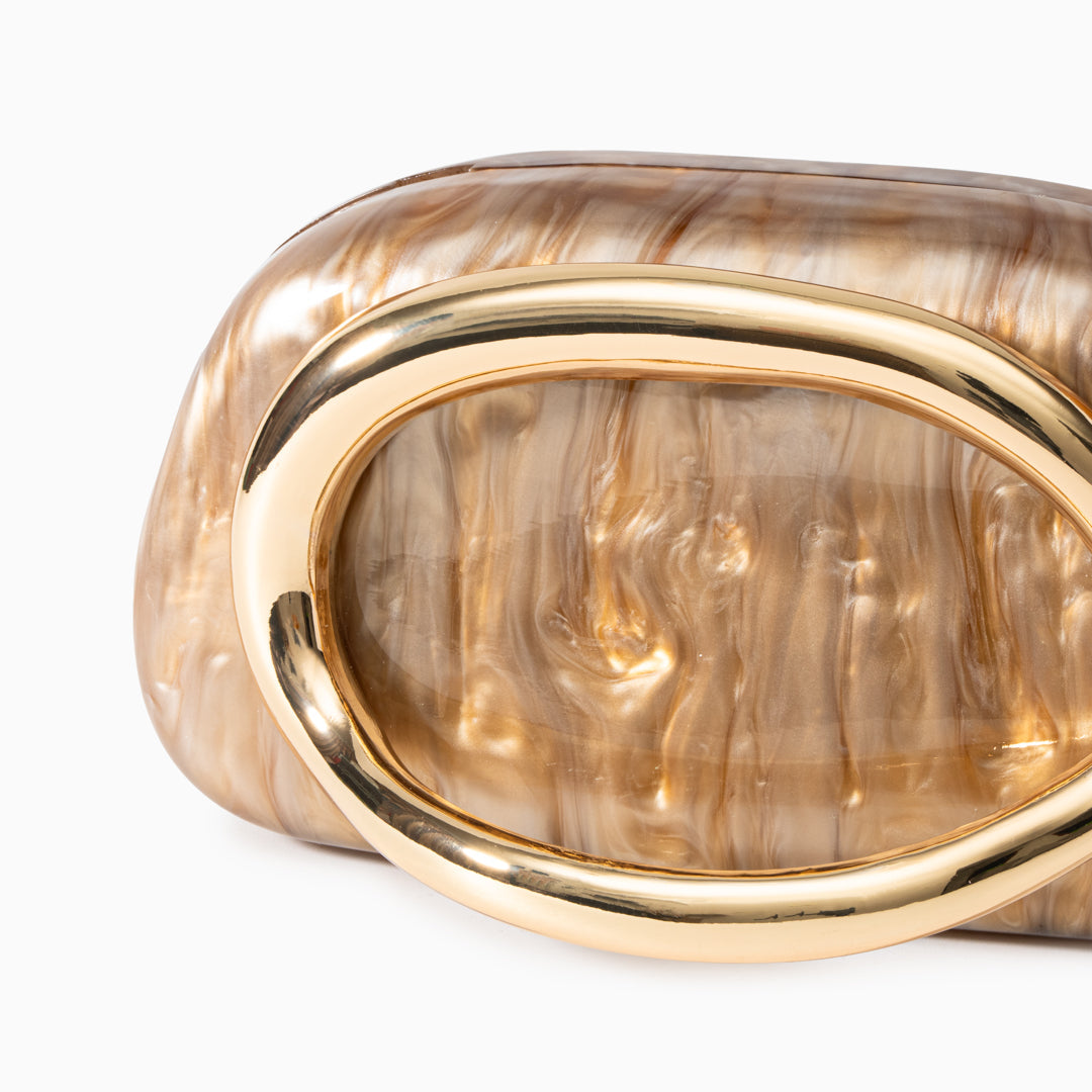 Sculptural gold clutch bag with a pearlescent acrylic finish, featuring a sleek design perfect for evening wear.