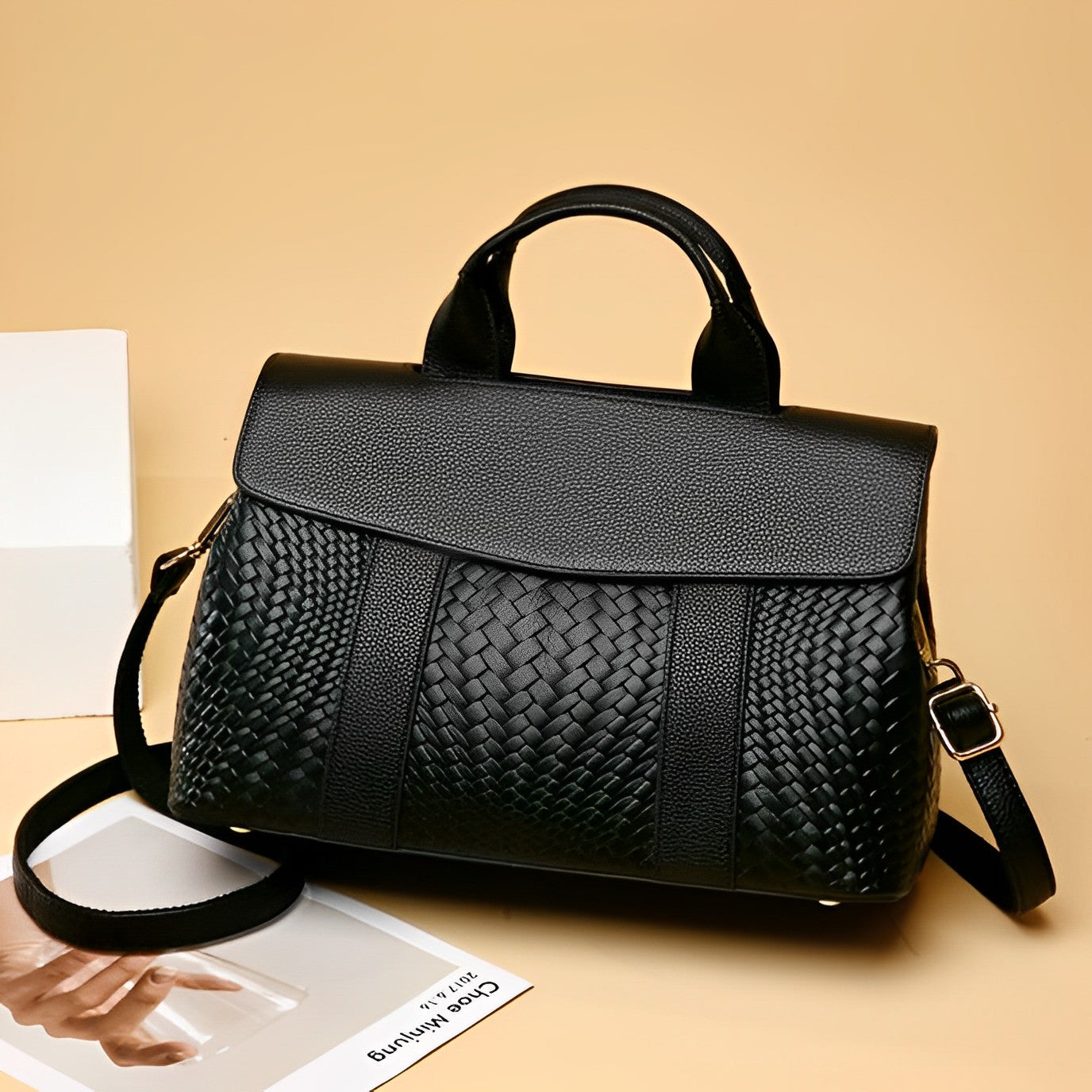 Black woven handbag on a beige background