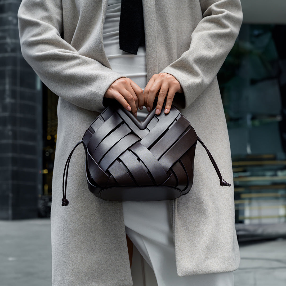 Sophia Woven Handbag featuring a unique inverted triangle handle and an elegant fabric design. 8